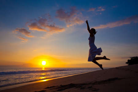 Young girl jumping in the sunsetの写真素材