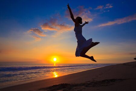 Young girl jumping in the sunsetの写真素材