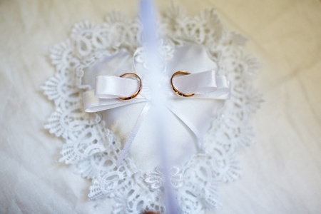 gold wedding rings on the white pincushionの写真素材
