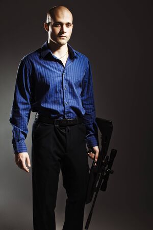 Portrait of a handsome young man holding a gun.の写真素材