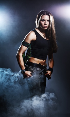 Sexy woman holding daggers with smokeの写真素材