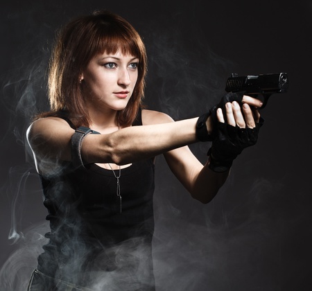 Sexy woman holding gun with smokeの写真素材