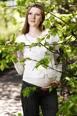 Beautiful pregnant woman relaxing in the parkの写真素材