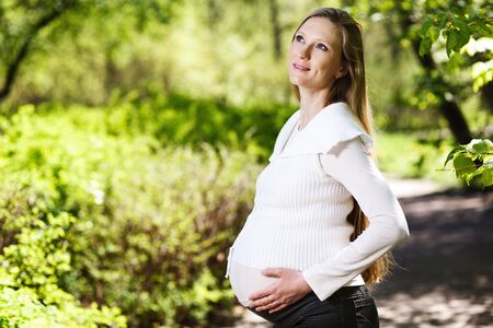 Beautiful pregnant woman relaxing in the parkの写真素材