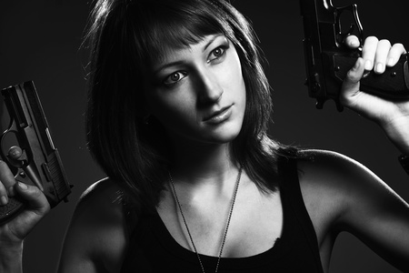 Sexy woman holding gun on grayの写真素材