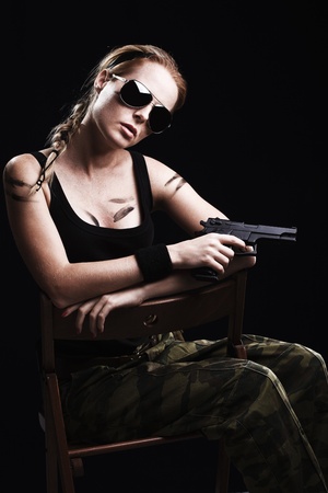 Shot of a sexy military woman posing with gunの写真素材