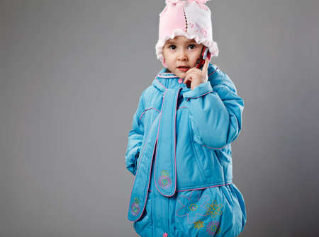 funny little girl on gray with phoneの写真素材