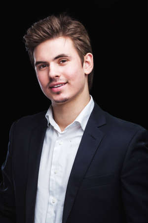 Fashion young businessman black suit on dark  backgroundの写真素材