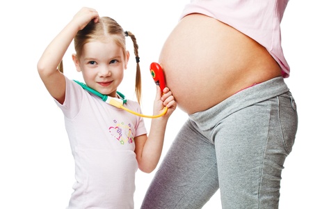 Beautiful pregnant woman with her daughter. Isolated on white backgroundの写真素材