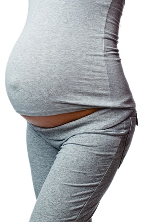 closeup of 9 months pregnant woman over whiteの写真素材