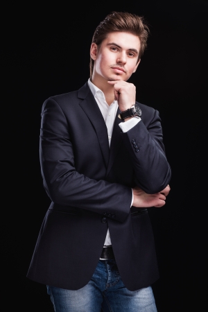 Fashion young businessman black suit on dark  backgroundの写真素材