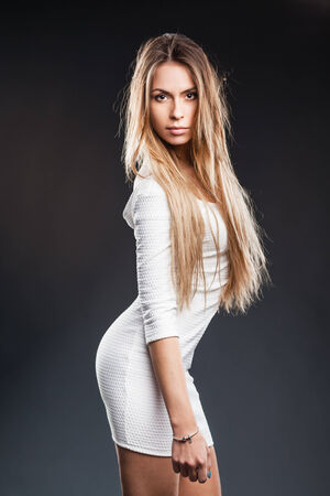 sexy blonde model with lovely long hair and a curvaceous body posing in white lingerieの写真素材