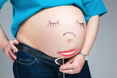 Belly of pregnant woman and smile on itの写真素材