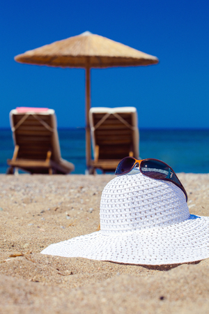 blue color of sea and hat on sand. Focus on hatの写真素材