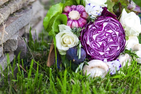The original unusual edible bouquet of vegetables on a grassの写真素材