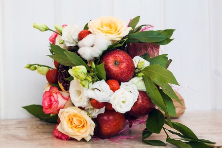 The original unusual edible bouquet of fruits on a woodの写真素材