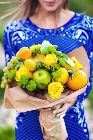The original unusual edible bouquet of fruits in woman handsの写真素材