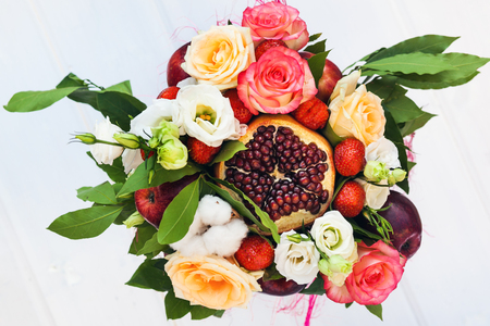The original unusual edible bouquet of fruits on a woodの写真素材