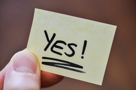 Success / Goal Concept - Fingers Holding Note With Handwritten YES Wordの写真素材