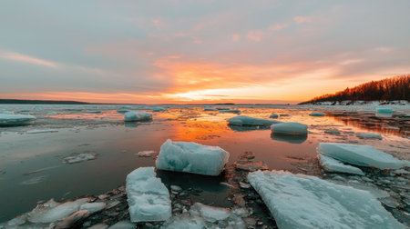 A breathtaking view of a sunset over icy waters, featuring floating icebergs bathed in warm colors. The serene atmosphere and tranquil sky showcase the beauty of nature.の素材