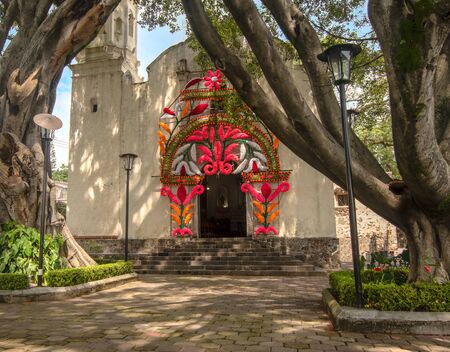 ancient catholic church mexico flower decoration green old tree blue sky no people front viewの写真素材