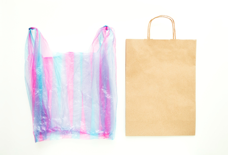 Ugly colorful plastic bag vs brown recyclable eco paper bag. Reduce, Reuse and Recycle concept. Flat lay, view from above, isolated on whiteの写真素材