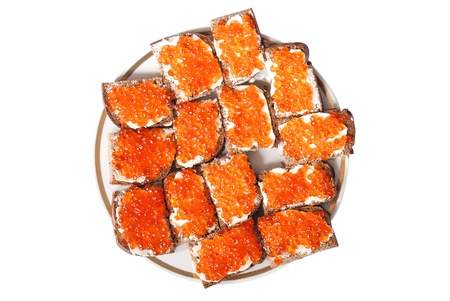 Slices of bread with red caviar on a plate isolated on a white background の写真素材