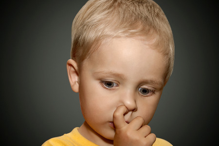 Young boy picking his nose.の写真素材
