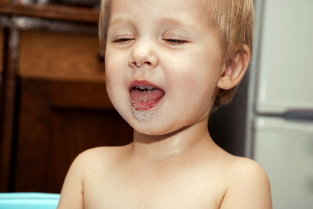 Little funny boy with a funny expression on his face washed in the bath.の写真素材