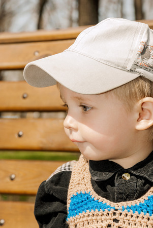 Portrait of little boy in cap outdoors.の写真素材
