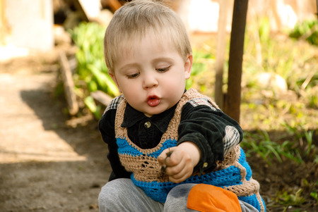 Little boy sitting in the garden playing ground.の写真素材