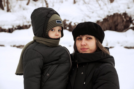 Mother with baby in the winter outdoors.の写真素材