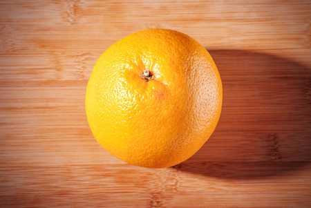 Ripe one grapefruit on wooden board.の写真素材