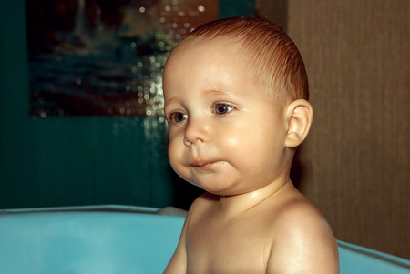 Baby face close-up bathing in the tub.の写真素材