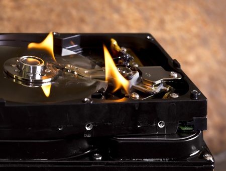 burning stack of hard disks in front of rusty backの写真素材