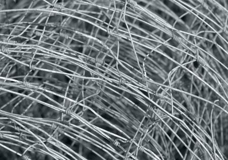 abstract detail of a rolled mesh wire fence made of metalの写真素材