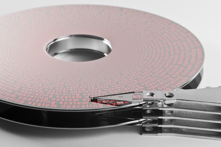 detail shot of a separated hard disk platter with actuator arm in light grey backAllegory theme...