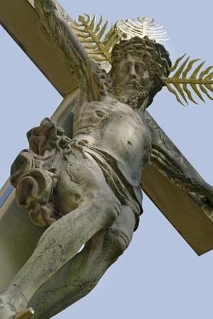 low angle shot of a old stone carved crucifix in a old graveyard in Freiburg im Breisgau, a city in Southern Germanyの写真素材