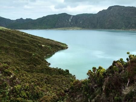 rocky overgrown lakeside scenery at Sao Miguel Islandの写真素材