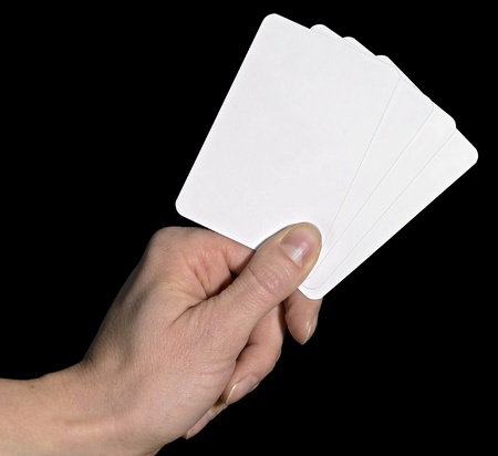 studio photography of a hand and white playing cards in dark backの写真素材