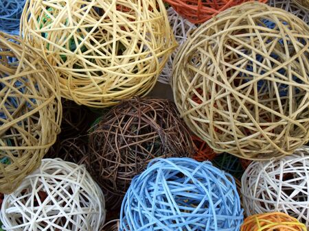 full frame background showing decorative balls made of wooden stipes in various colorsの写真素材