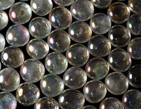 full frame abstract background picture with iridescent glass beads in dark backの写真素材