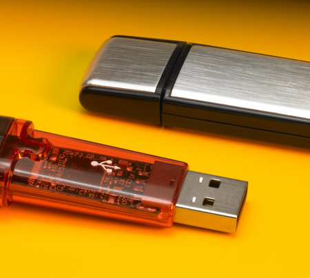 studio photography of 2 USB sticks in orange backのeditorial素材