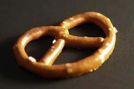 closeup of a salted small pretzel in dark back. A pretzel is a special bakery product in Southern Germanyの写真素材