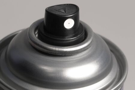studio photography of showing the spray of a aerosol can in grey back
