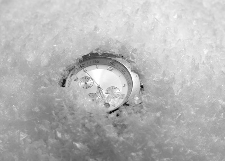 studio photography of a wristwatch dial in artificial snowの写真素材