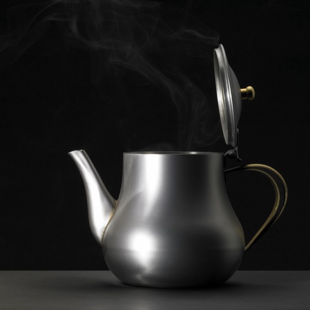 Studio photography of a metallic tea pot and some damp in dark backの写真素材