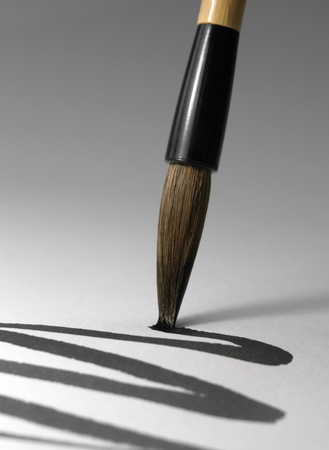 detail of a chinese brush while drawing a line in light backの写真素材