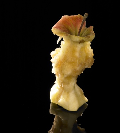 studio shot of a apple core in black reflective backの写真素材