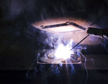 welding scenery with hard disk drive, welding mask detail and flashy light